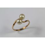 A Lady's Yellow Gold and Pearl Cross Over Ring