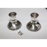 PAIR OF WEIGHTED STERLING SILVER CANDKLESTICKS 8 CMS HIGH