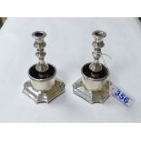 A PAIR OF SILVER PLATED CANDLESTICKS AND A PAIR OF PLATED ENGRAVED NAPKIN RINGS IN CASE