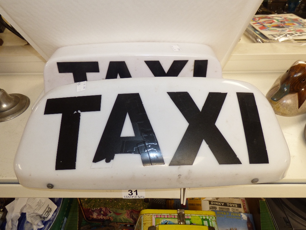 TWO MAGNETIC TAXI SIGNS FOR CAR USE. BLACK TEXT ON WHITE BACKGROUND