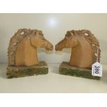 A PAIR OF HORSES HEAD BOOKENDS ON FAUX MARBLE BASES