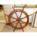 A WOODEN SHIPS WHEEL - 90 CM IN DIAMETER