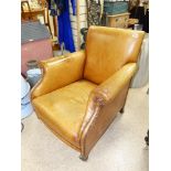 AN EARLY 20TH CENTURY LEATHER CLUB CHAIR ON RAISED WOODEN SUPPORTS WITH CASTORS, 78 CM TALL