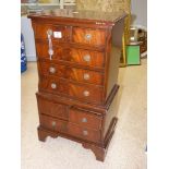 A REPRODUCTION MAHOGANY MINIATURE CHEST ON CHEST WITH 8 DRAWERS. 80 CM TALL