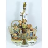 AN UNUSUAL HUMMEL CERAMIC TABLE LAMP BASE, 29 CM TALL, TOGETHER WITH TWO GOEBEL CERAMIC FIGURES