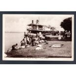 Mali, French Africa, paddle steamer with passengers and others on the river bank. Printed