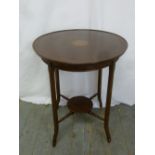 An Edwardian mahogany circular side table with satinwood inlay on four tapering legs