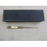 A silver and Mother of Pearl letter opener in original packaging