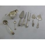 A quantity of silver and white metal to include a sauce boat and ladle, three cake slices, three