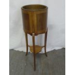 An Edwardian cylindrical inlaid wooden plant stand on three outswept supports