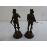 A pair of bronze figurines of musketeers on raised circular plinths