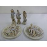 A pair of bisque figural wall plaques and three figurines in 18th century costume