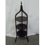 Mahogany three tier plate stand surmounted by a carved finial