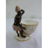A Meissen sweetmeat dish in a the form of a blackamoor with feather head dress and skirt, marks to