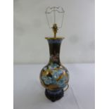 An Oriental cloisonné baluster form lamp stand decorated with dragons and stylised clouds