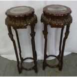 A pair of Chinese hardwood plant stands with circular inset marble tops on four carved supports