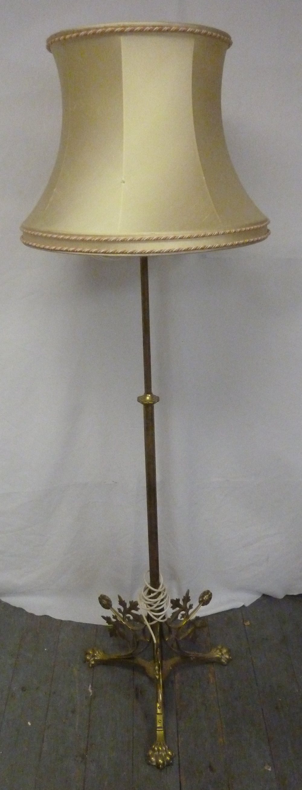 An Art Nouveau style brass standard lamp with silk shade