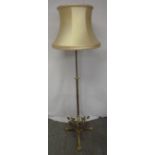 An Art Nouveau style brass standard lamp with silk shade