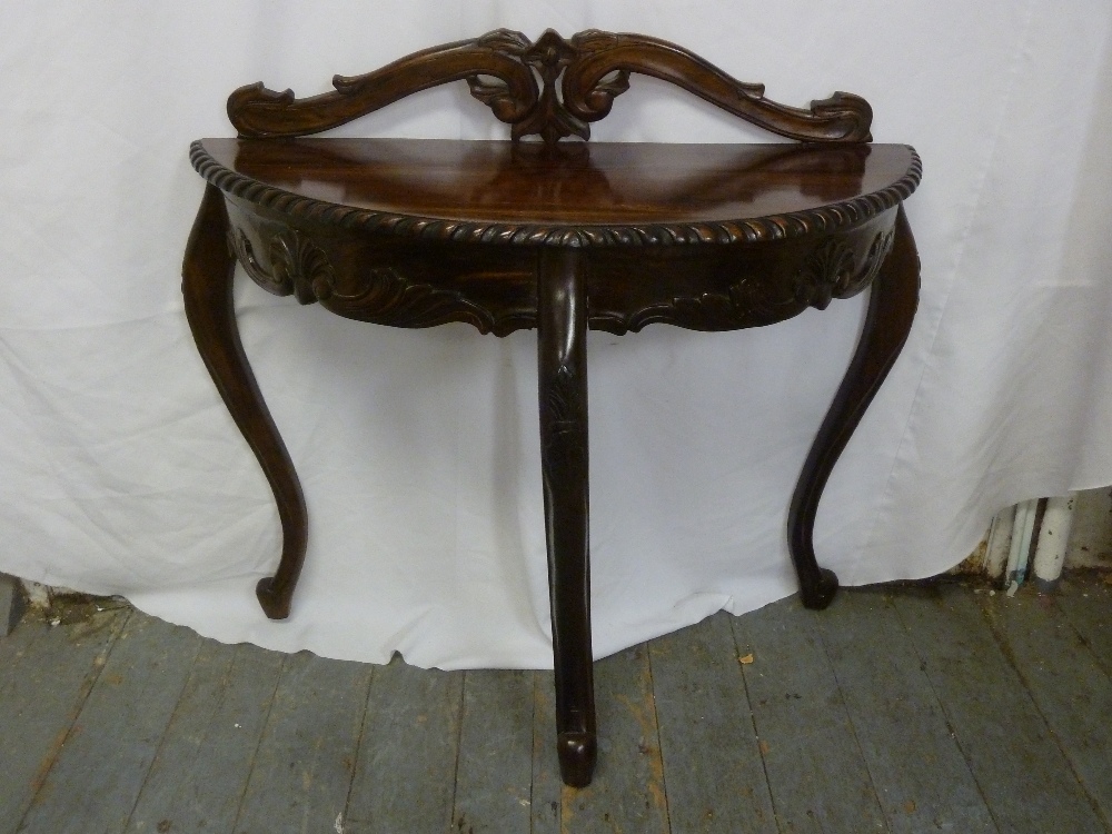 A mahogany D shaped hall table with gadrooned border on three cabriole legs