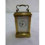 A miniature brass carriage clock, Roman numerals, swing handle and moulded case