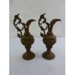 A pair of gilt metal ewers of classical form with scroll pierced handles on raised circular bases