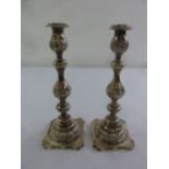 A pair of silver baluster form table candlesticks on shaped square bases, London circa 1910