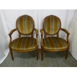 A pair of mahogany upholstered armchairs on turned tapering legs