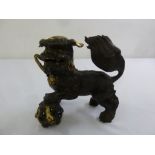 An Oriental part gilded metal figurine of a dog of foe