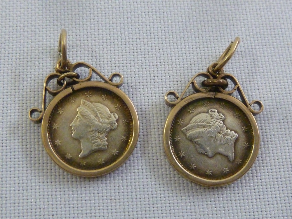 A pair of USA 1 Dollar silver coins set in gold pendants