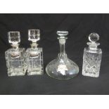 A pair of square cut glass decanters with silver collars and silver brandy and whisky labels and a