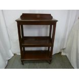 A Victorian rectangular mahogany three tier bookshelf on original brass castors