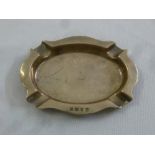 A silver ashtray of circular form