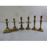 Three pairs of brass table candle sticks of various shapes and styles
