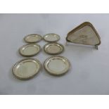 Six white metal coasters stamped sterling and a white metal napkin holder stamped sterling