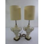 A pair of Blanc de Chine table lamps in the form of vases with scroll pierced side handles to