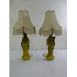 A pair of Oriental ceramic table lamps in the form of a male and female on raised circular bases