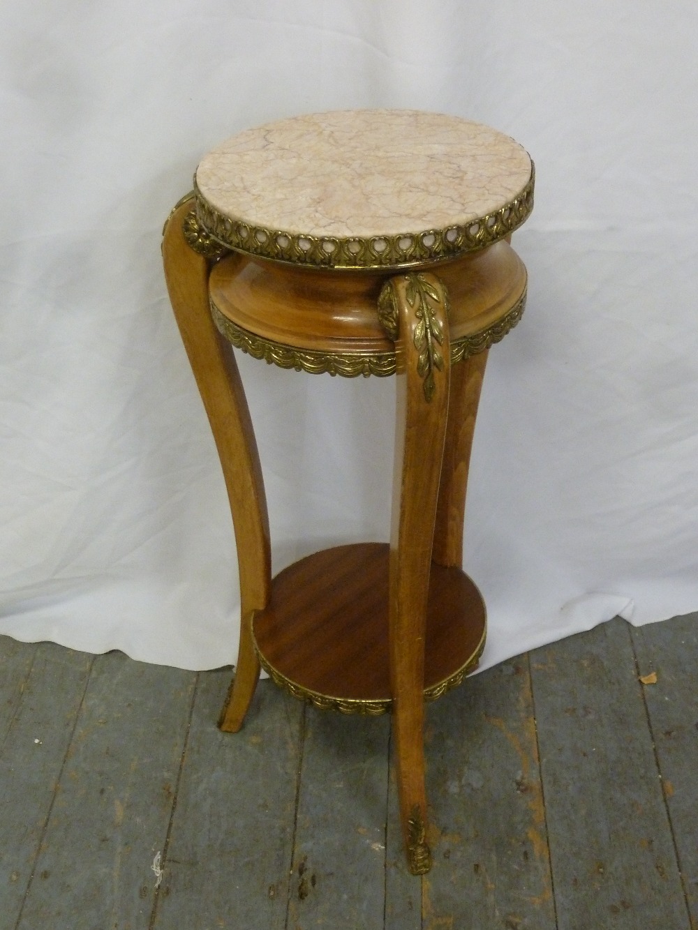 A French style circular side table on three legs with gilt metal mounts and pink marble inset top