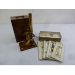 A quantity of prepared microscope slides and an R and J Beck brass microscope in fitted mahogany