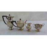 A three piece silver teaset of panelled form and a matching silver plated hot water jug, Sheffield