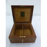 A rectangular wooden humidor with brass mounts and hinged cover