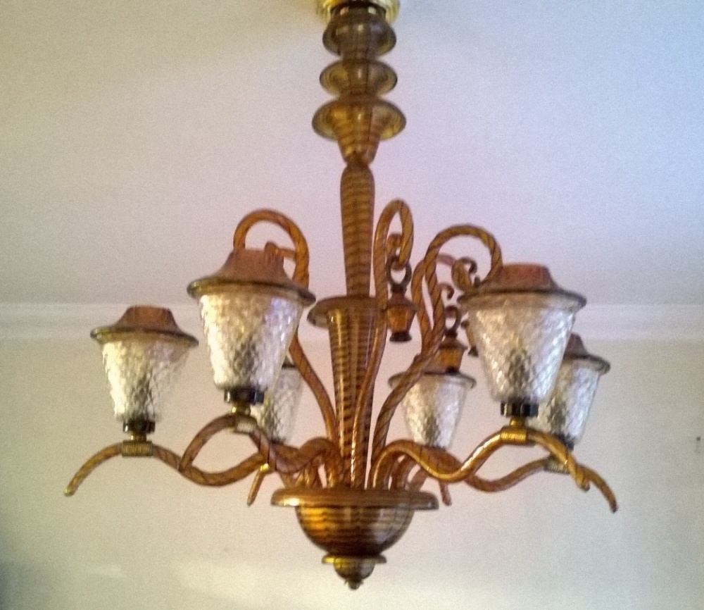 A Murano glass six branch chandelier, the scrolling arms supporting brown glass lantern shades, A/F