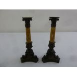 A pair of late 19th century bronze and marble columnular candlesticks on triform bases
