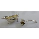 A silver sauce boat, oval cut edge on three scroll feet and an unusual conch ladle