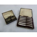 A cased pair of Scottish silver napkin rings and a cased set of tea knives