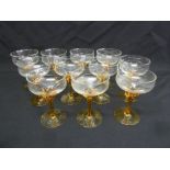 A set of eleven Art Deco style cocktail glasses with orange twisted stems on raised circular bases