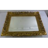 A rectangular wall mirror with pierced and carved gilt wooden frame