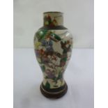 An Oriental crackle glaze baluster vase decorated with warriors, on hardwood stand