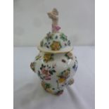 A Meissen style urn and cover with hand painted and applied flowers, the pull off cover with putti