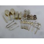 A quantity of silver to include napkin rings, sugar tongs, salts, spoons and dressing table brushes