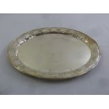 An oval white metal tray the everted rim embossed with berries and leaves